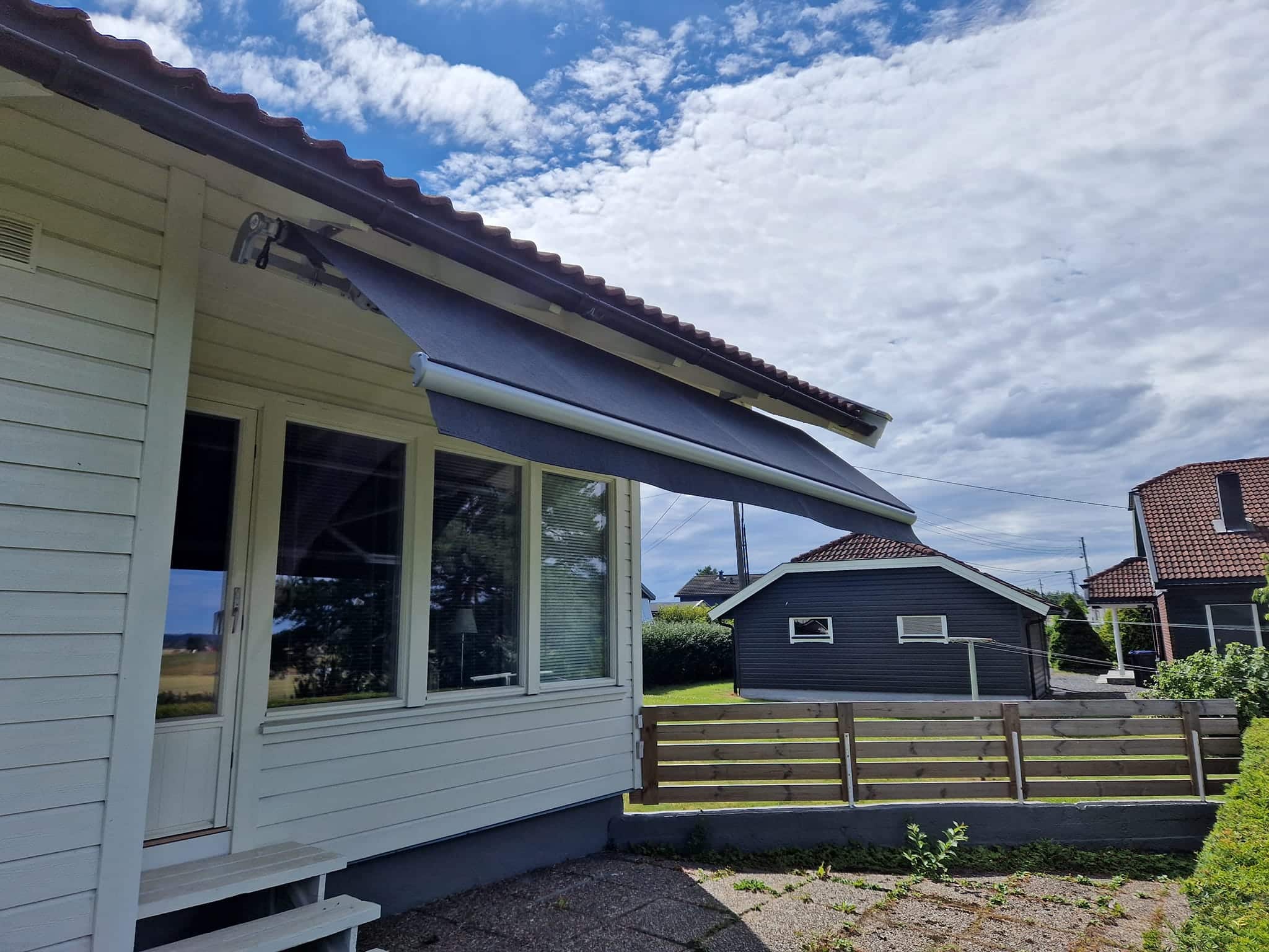 Montert solskjerming på et hvitt hus